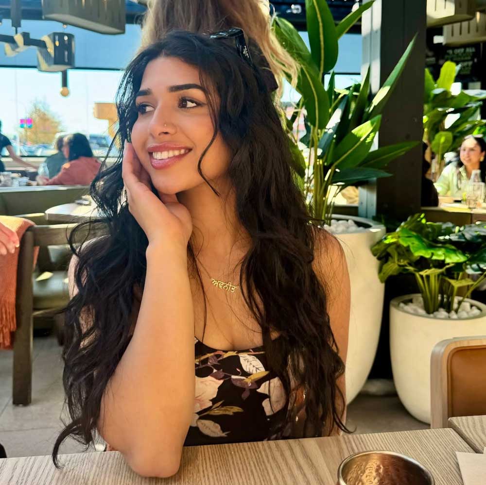 Customer photo of young girl wearing custom Punjabi name necklace in everyday style