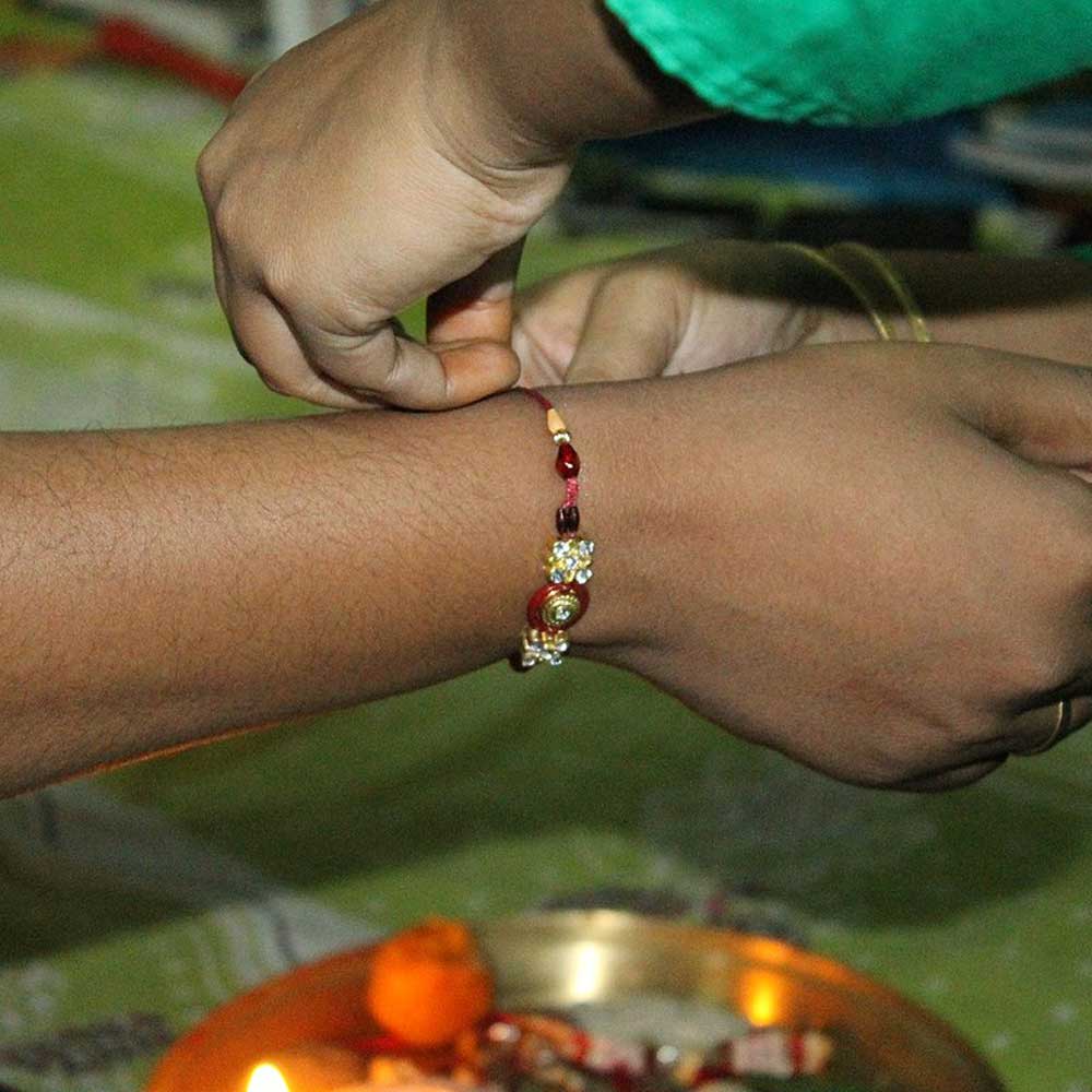 sister tying rakhi thread to brother for raksha bandhan