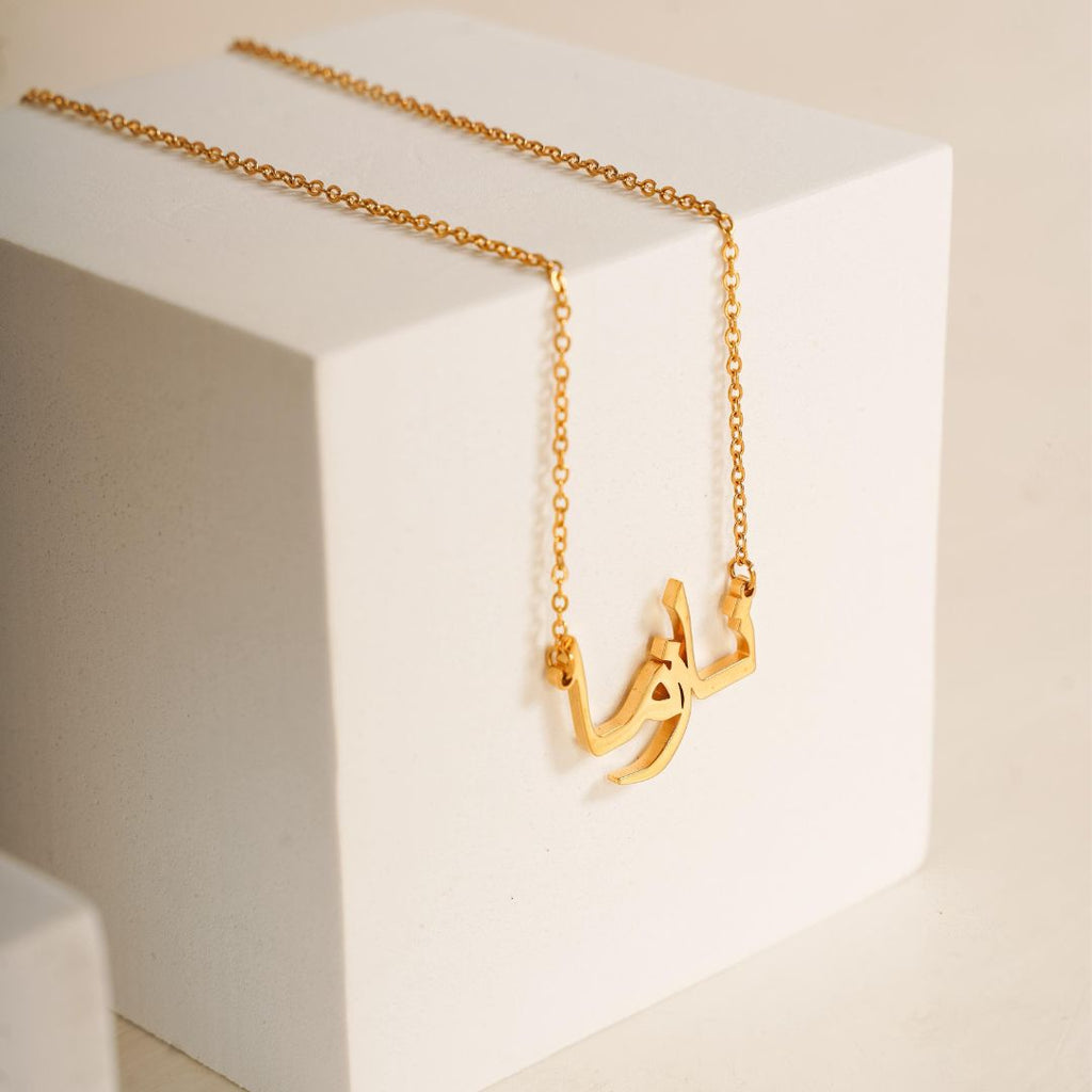 personalised arabic name necklace in 18k gold plated resting on a white box