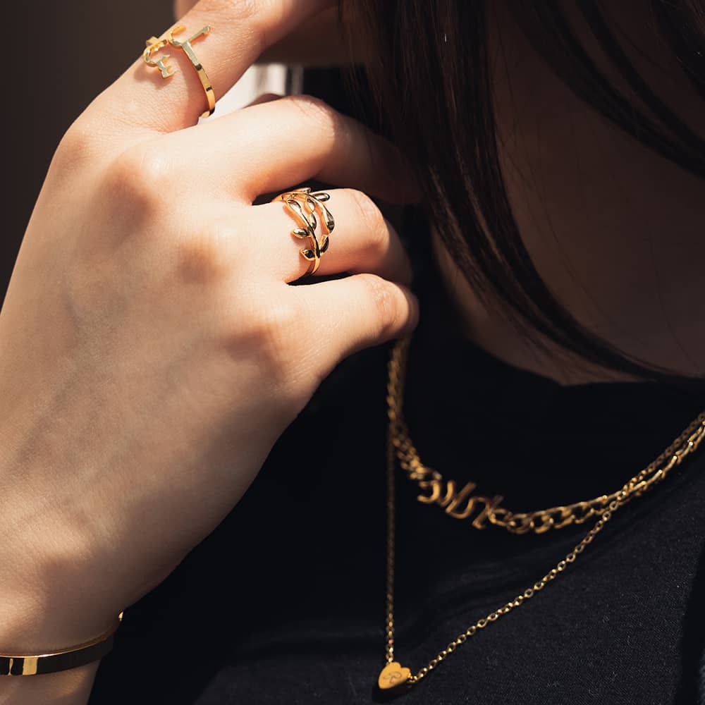 woman wearing 18ct gold plated jewellery including cuban chain name necklace and personalised rings