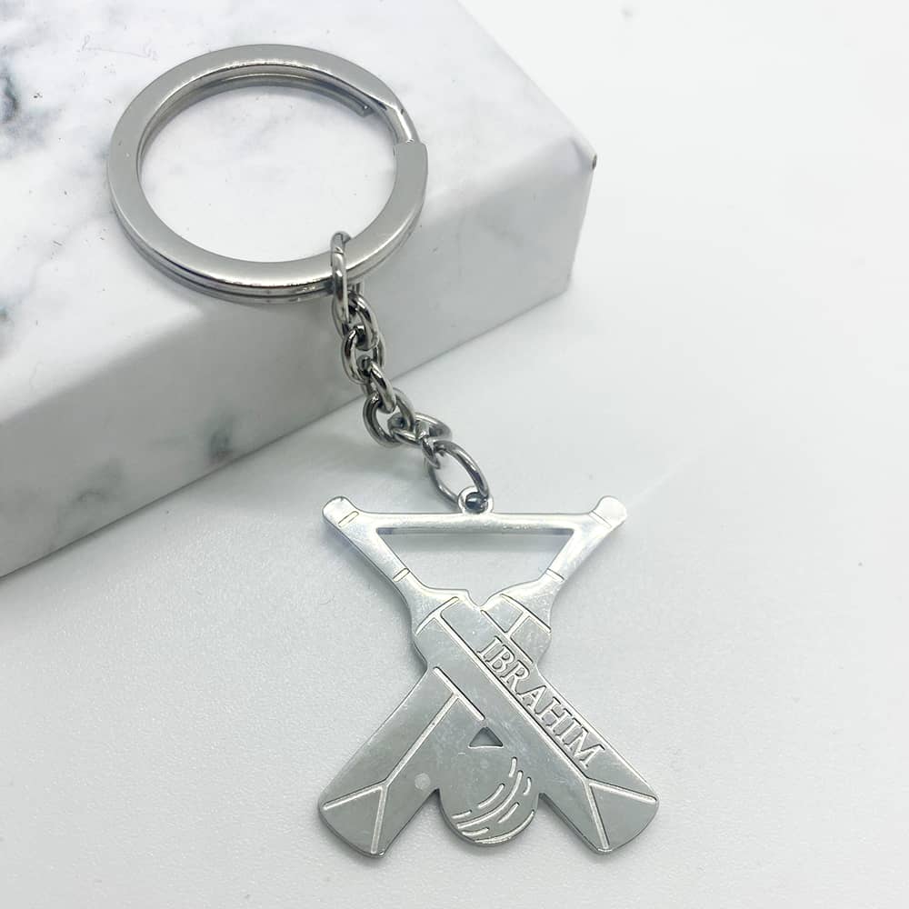 keychain design in silver for men with cricket bats and ball and custom name negraving in any language or name.