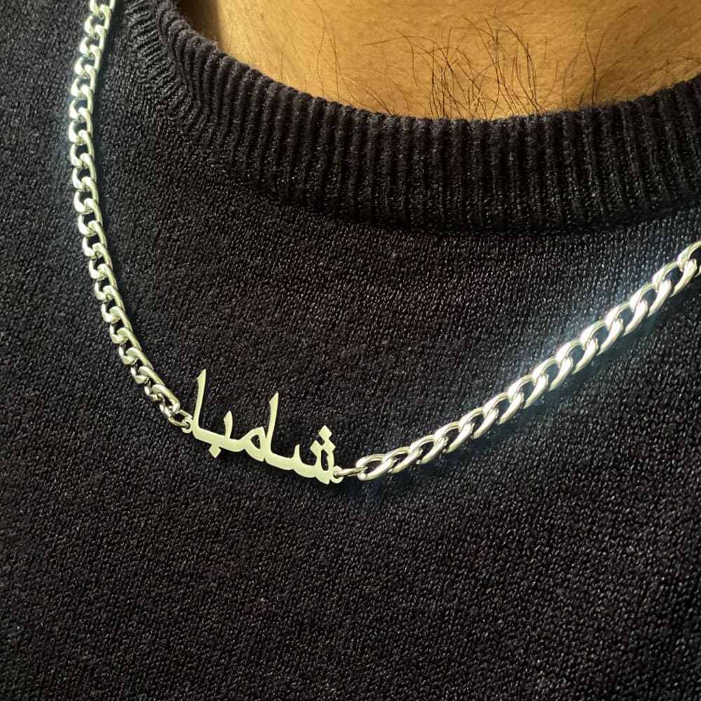 close up of man wearing silver cuban name necklace chain