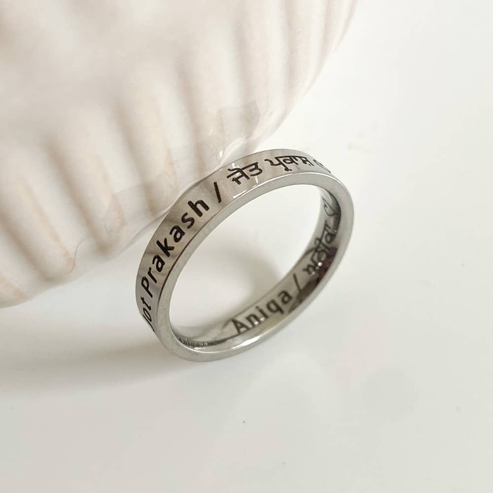 silver couples ring with english and punjabi engravings on inside and outside of band ring