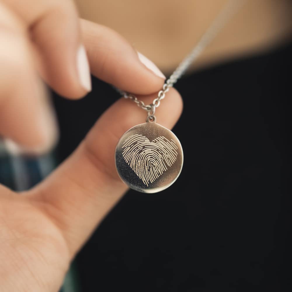 woman wearing silver necklace and closeup of the personalised fingerprint engraving