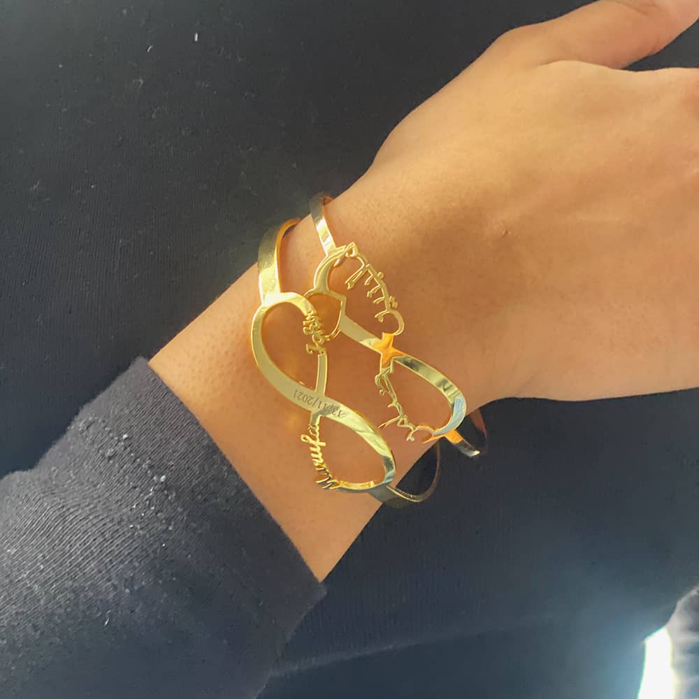 woman wearing two 18ct gold plated custom name arabic bangle with an infinity symbol for couples