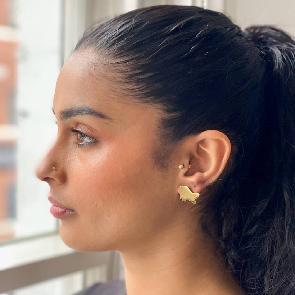 woman wearing 18ct gold plated stud earrings in the shape of kashmir
