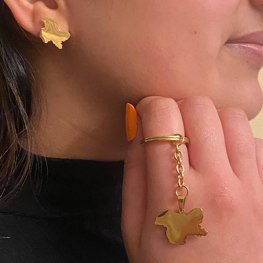 woman wearing stud earring with map of kashmir and kashmir pendant keychain