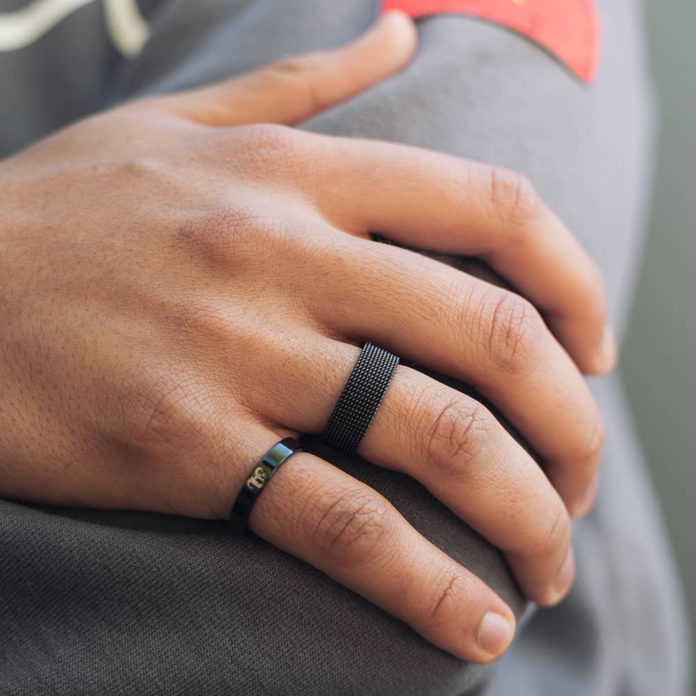 man wearing black band ring for men with white arabic engraving on outside