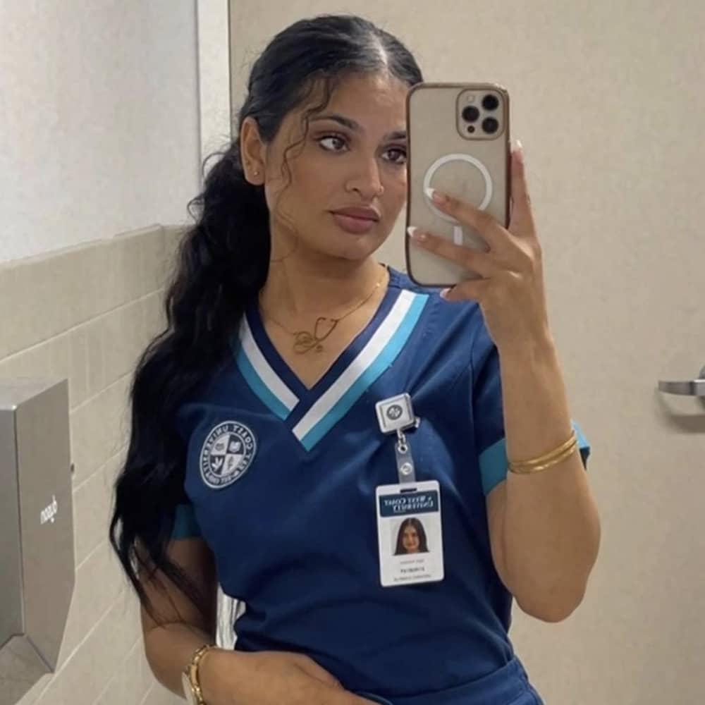 medical nurse at hospital wearing gold personalised name necklace in arabic with stethoscope design