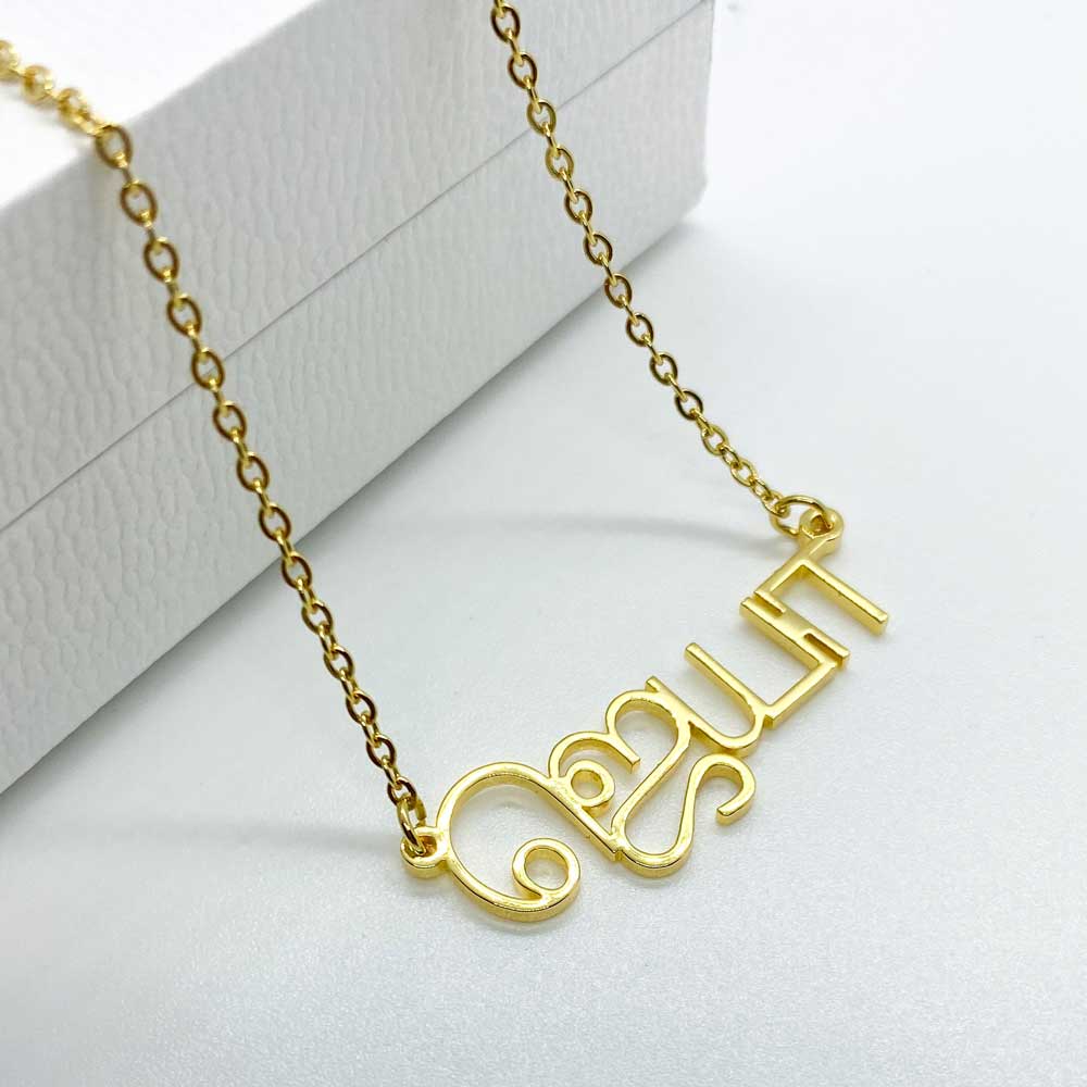 Flat lay of a single gold Custom Tamil Name Necklace