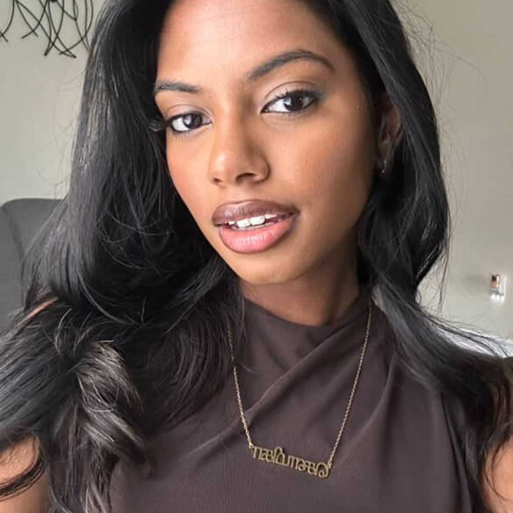 Influencer Shaumiga wearing the gold Tamil necklace with a casual Western top with wavy hair