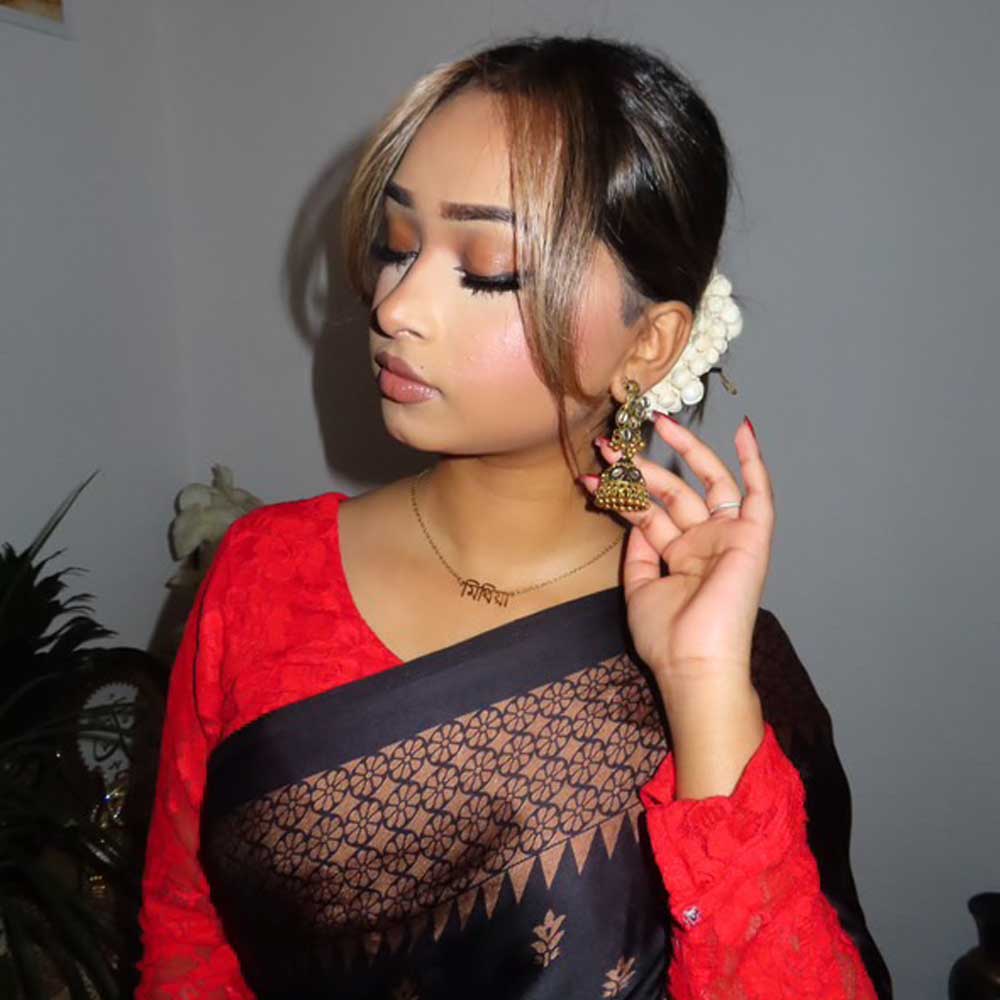Influencer Mithia wearing gold Bangla name necklace with a black and red saree