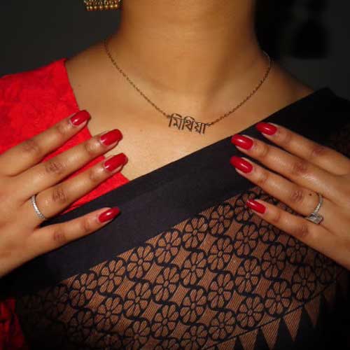 Close-up of Mithia’s neck wearing gold Bangla name necklace for women