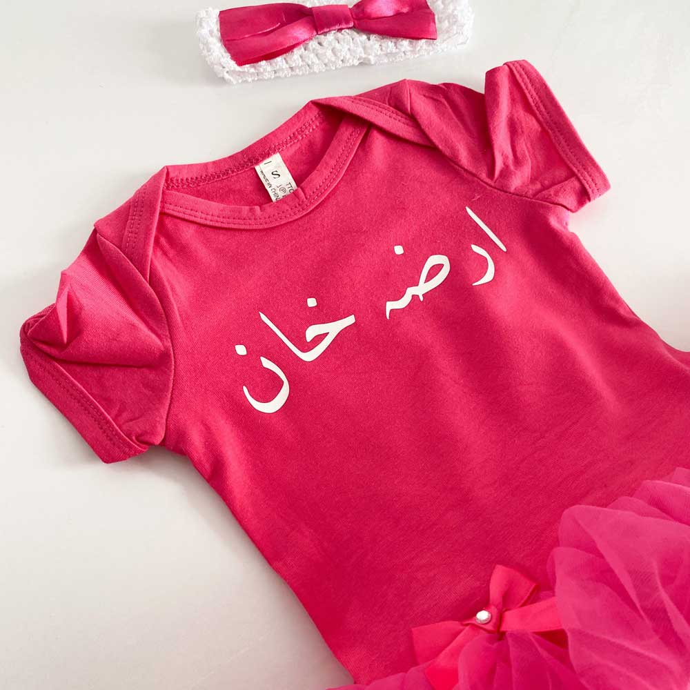 close up of personalised name in arabic on baby girl tutu dress with matching pink headband