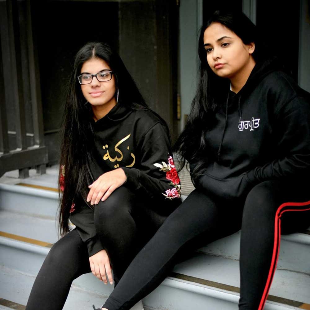 black hoodies for sisters with names in arabic and punjabi and floral sleeve embroidery