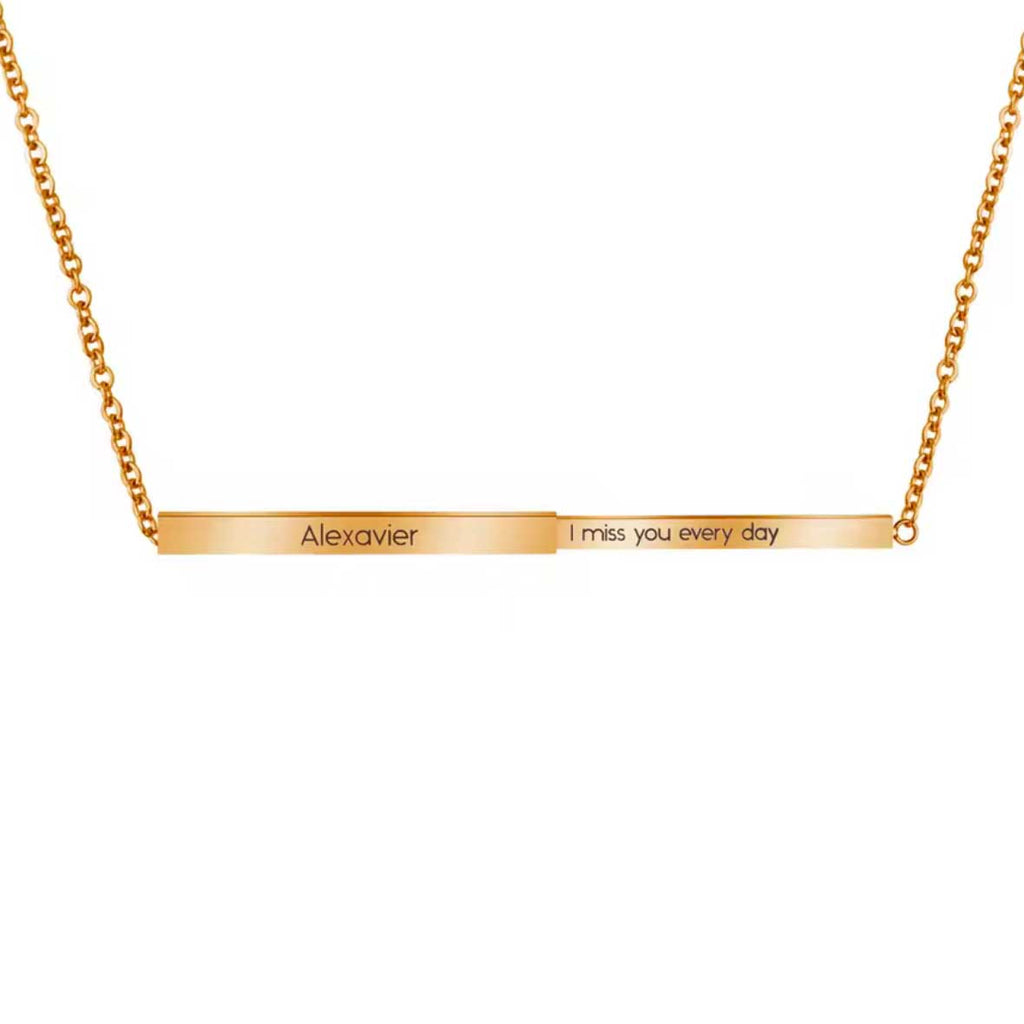 Gold necklace with engraved message on a white background
