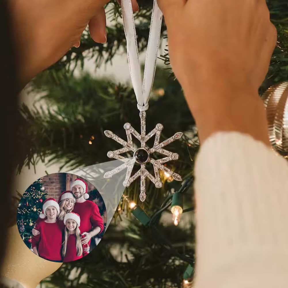 woman hanging snowflake ornament on Christmas tree with hidden family photo inside