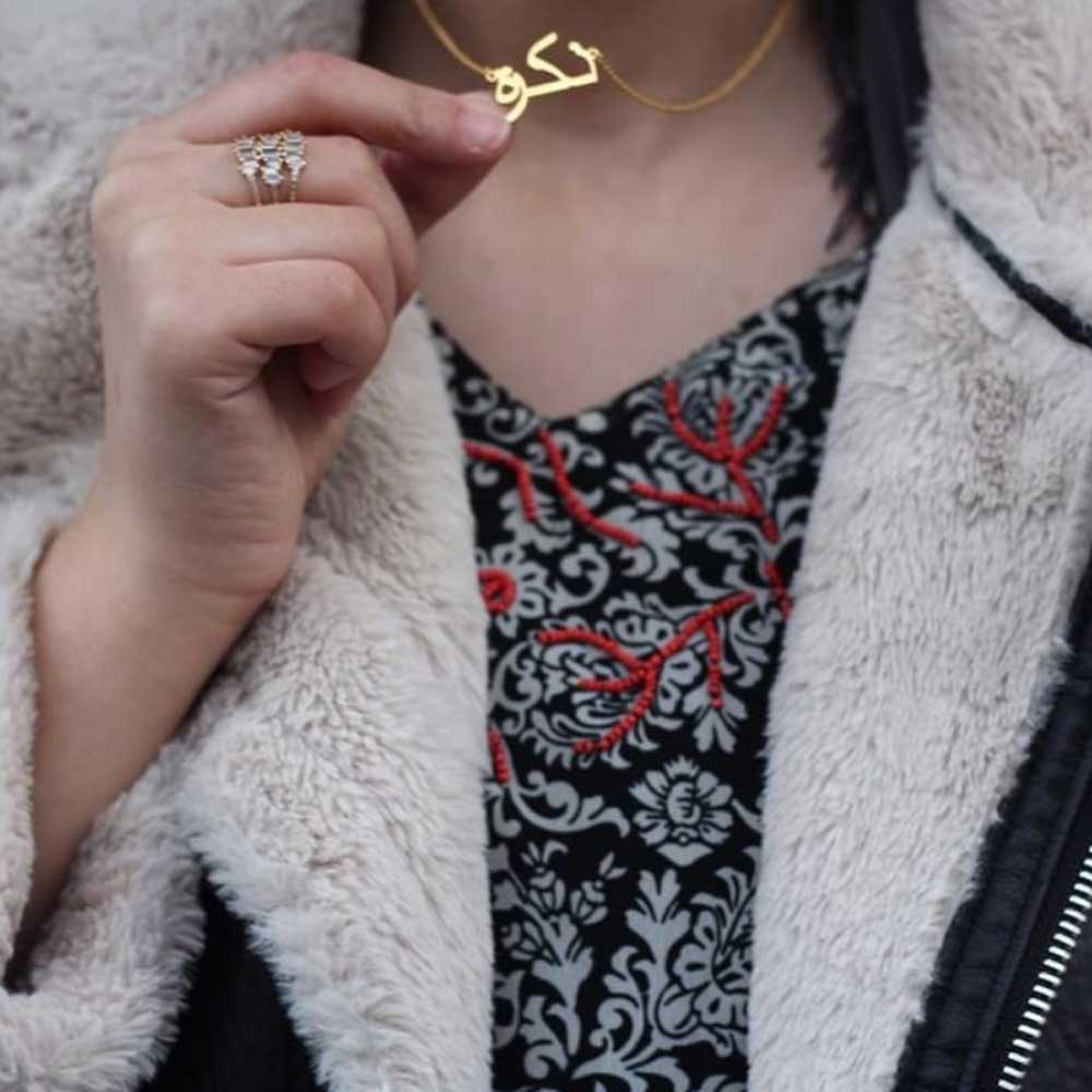 Close-up of influencer Zikra wearing Arabic name necklace in gold