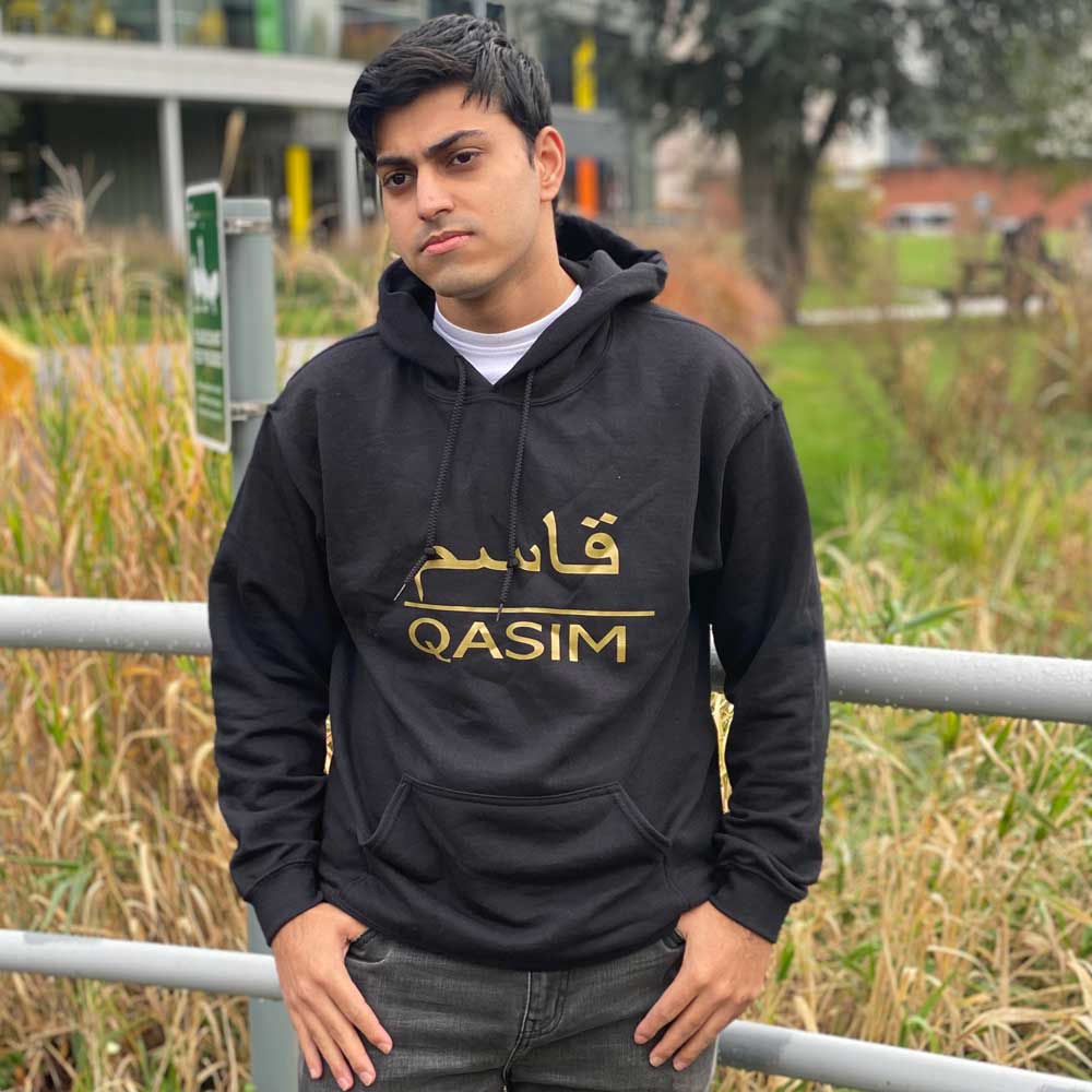 man wearing black personalised hoodie with arabic and english name in metallic gold