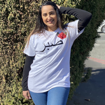 White tshirt with black custom Arabic text and red floral rose embroidery