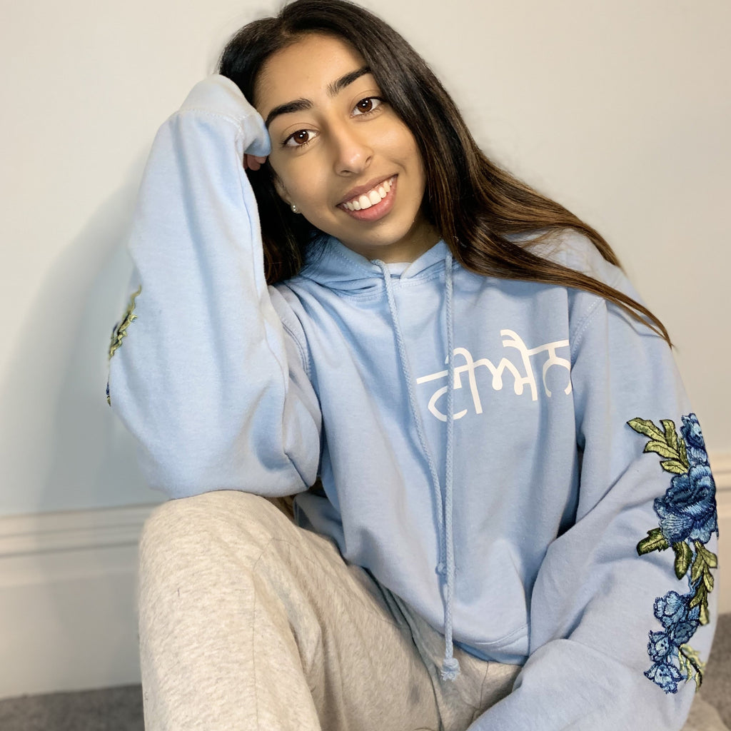 light blue hoodie with white Punjabi name print on left chest and blue sleeve embroidery