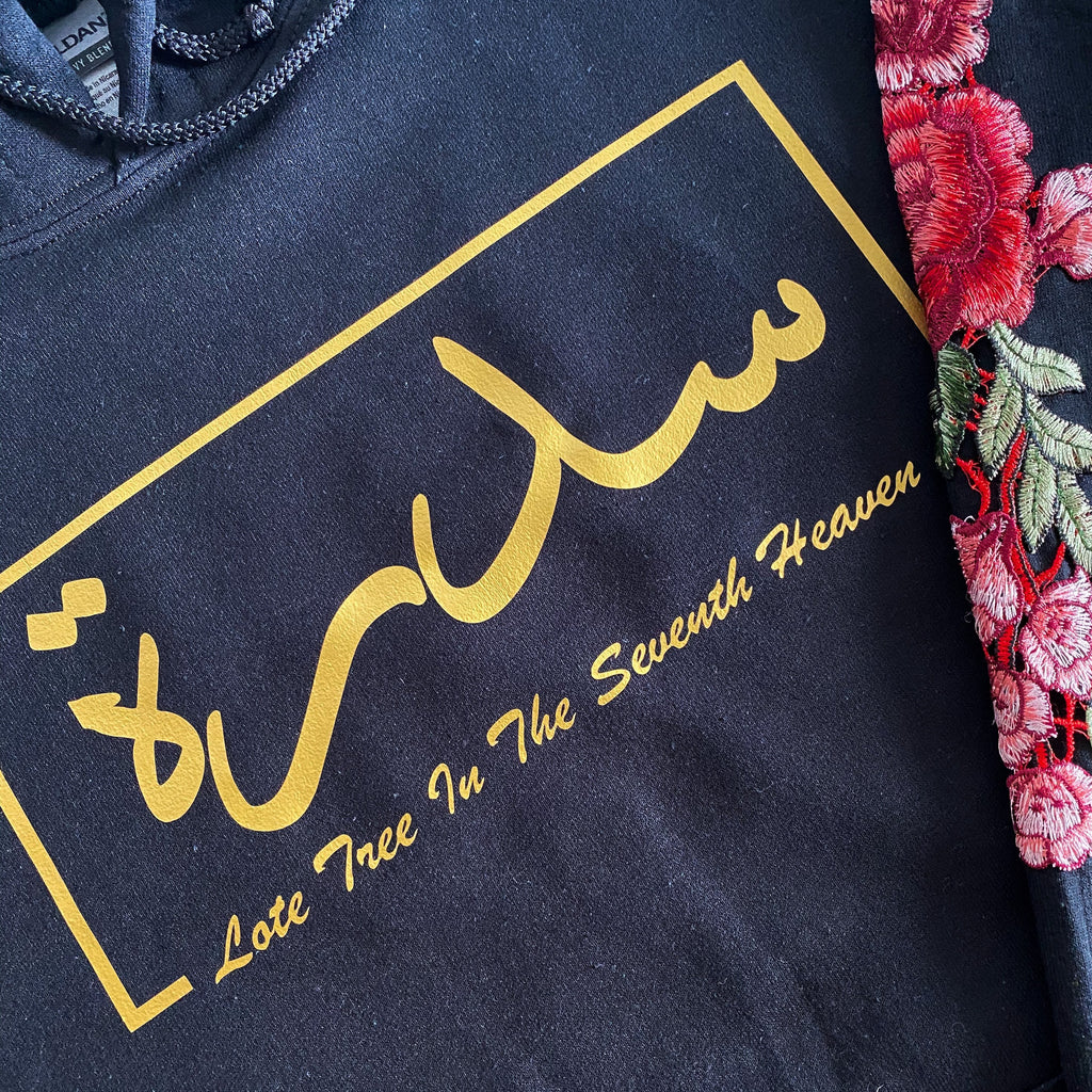 black hoodie with metallic gold Arabic and English name design printed across the chest and red sleeve embroidery
