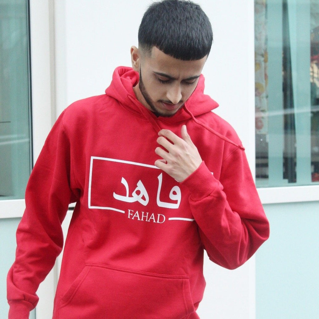 red hoodie with white box design including Arabic and English name printed across the chest