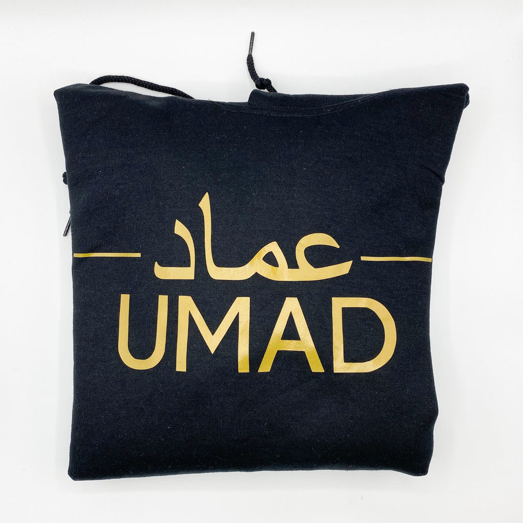 black hoodie with personalised Arabic and English name in metallic gold across the middle