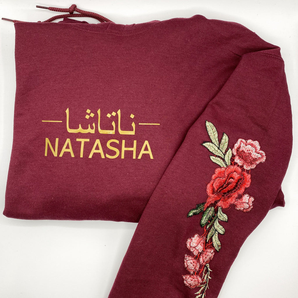 maroon hoodie with metallic gold design small of Arabic and English name with red floral sleeve embroidery