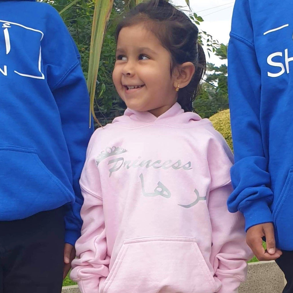 customer wearing a light pink hoodie with silver princess design and Arabic name