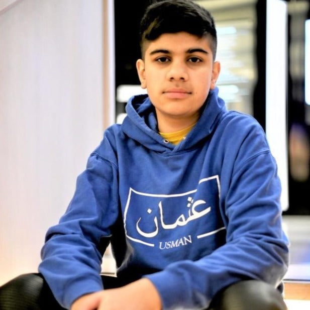 royal blue hoodie with white box design including Arabic and English name printed across the chest